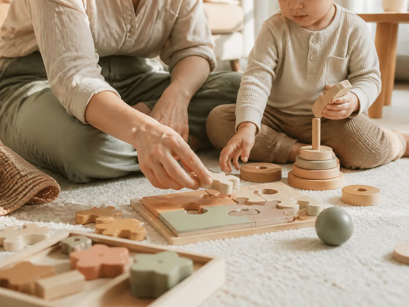 Ein Elternteil und ein Kleinkind entdecken gemeinsam Holzspielzeug